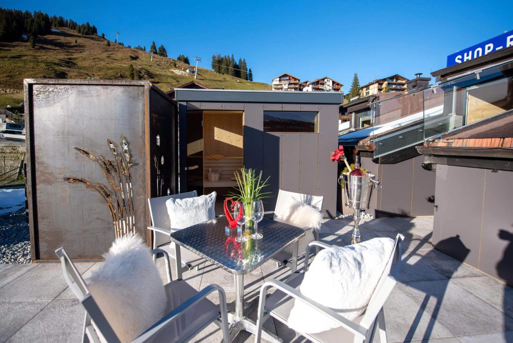 Gemütliche Terrasse mit Tisch und Stühlen, umgeben von alpiner Landschaft in Königsleiten.