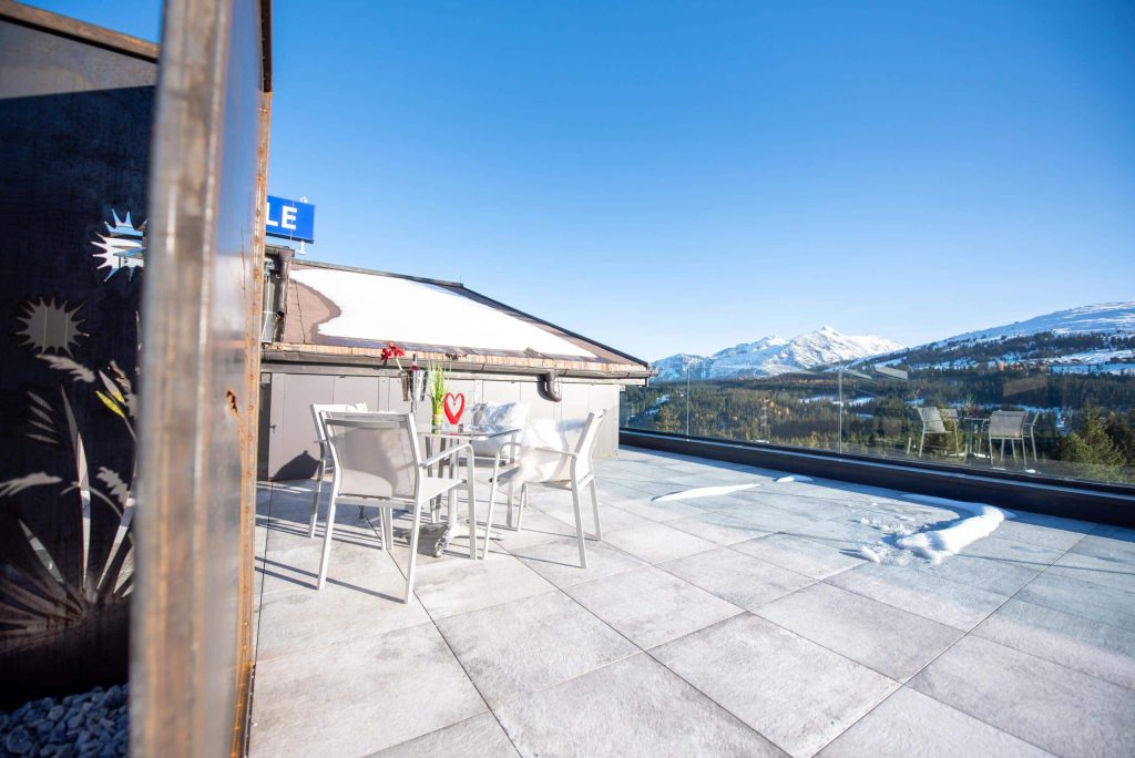 Sonnige Terrasse mit Blick auf schneebedeckte Berge in Königsleiten für den Winterurlaub.