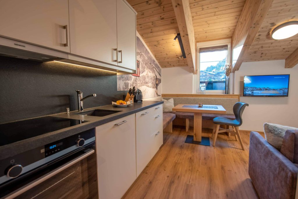 Moderne Küche mit Sitzecke und Fenster im Winterurlaub in Königsleiten.